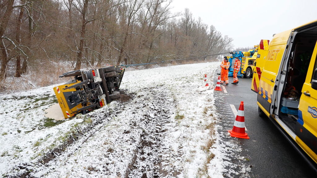 Strooiwagen glijdt van de Eemmeerdijk, auto's glibberen op de Hopweg